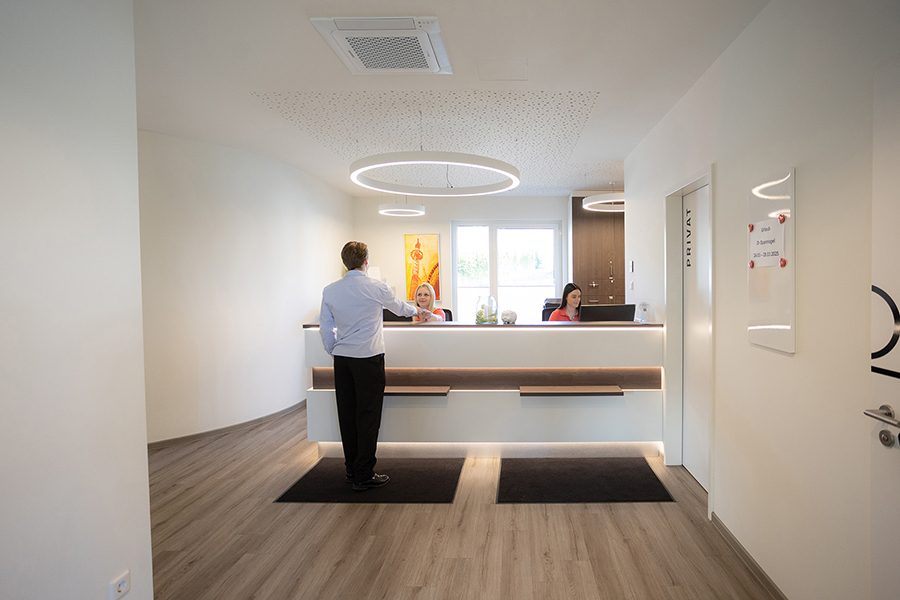 Empfangsbereich Moderner Empfangsbereich mit einem Schreibtisch und einem Kunden am Empfang.